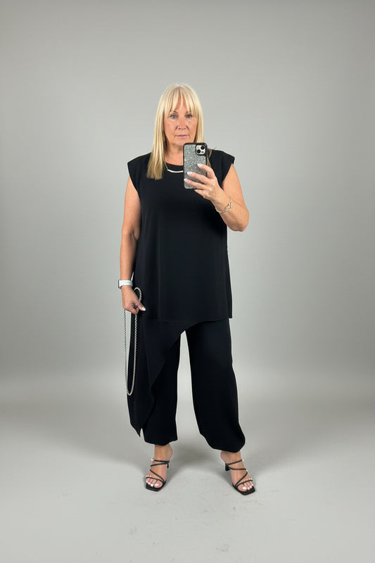 Model wearing the black Tanya asymmetrical suit taking a selfie