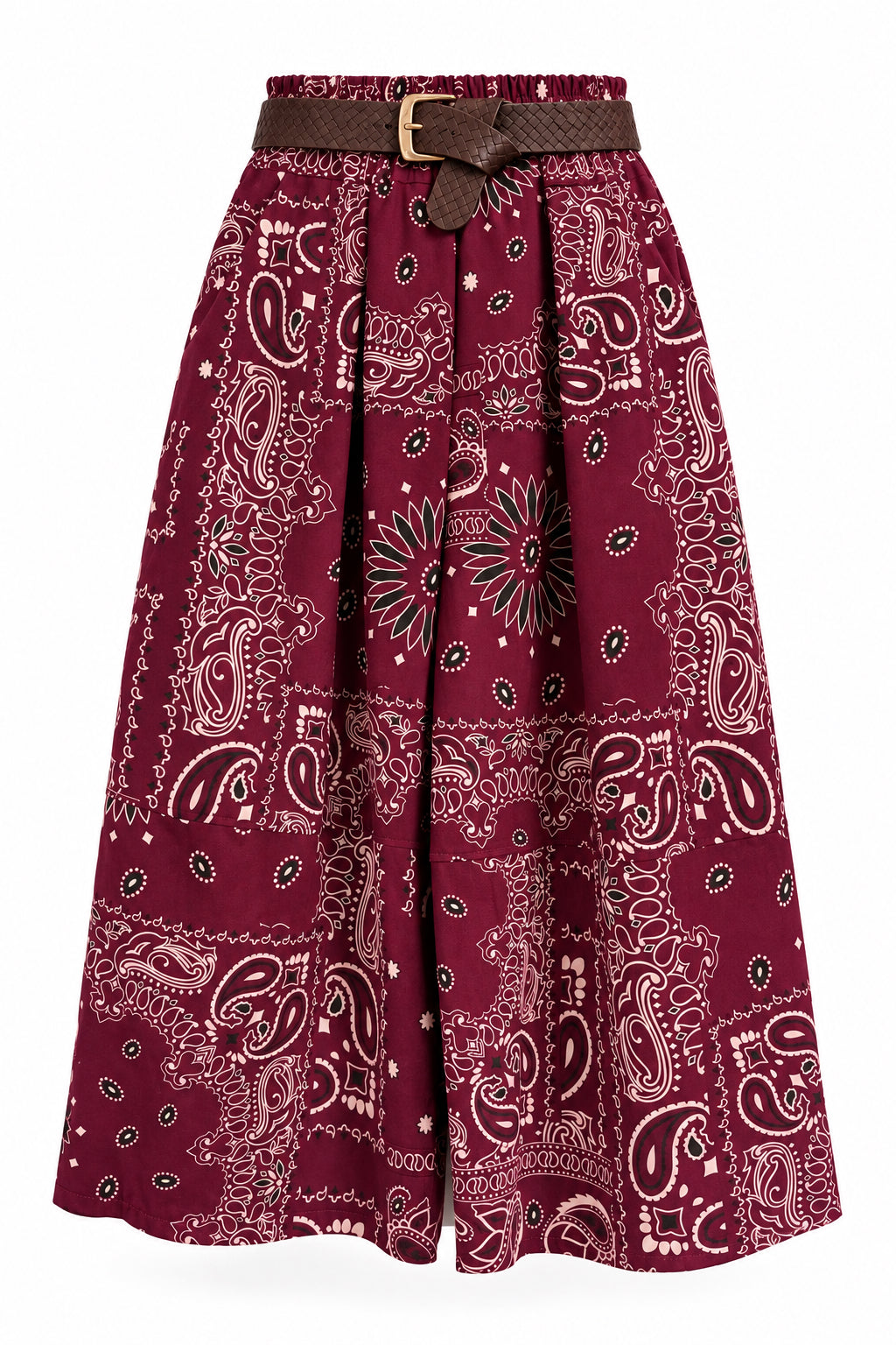 A pair of pleated wide-leg pants in a deep burgundy paisley bandana print, featuring a matching brown belt with a gold buckle, hanging on a black hanger against a white paneled wall.