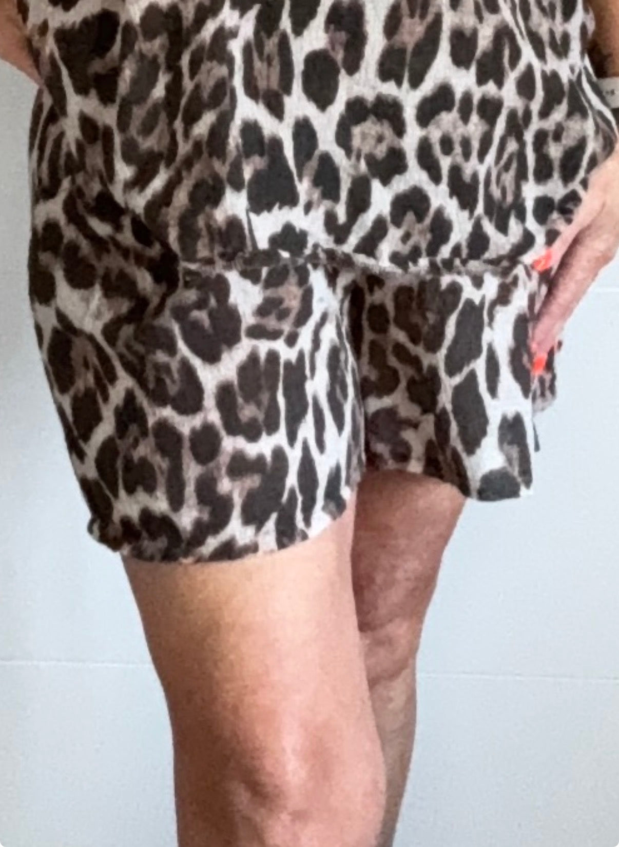 Leopard print shorts worn by a person on a white background