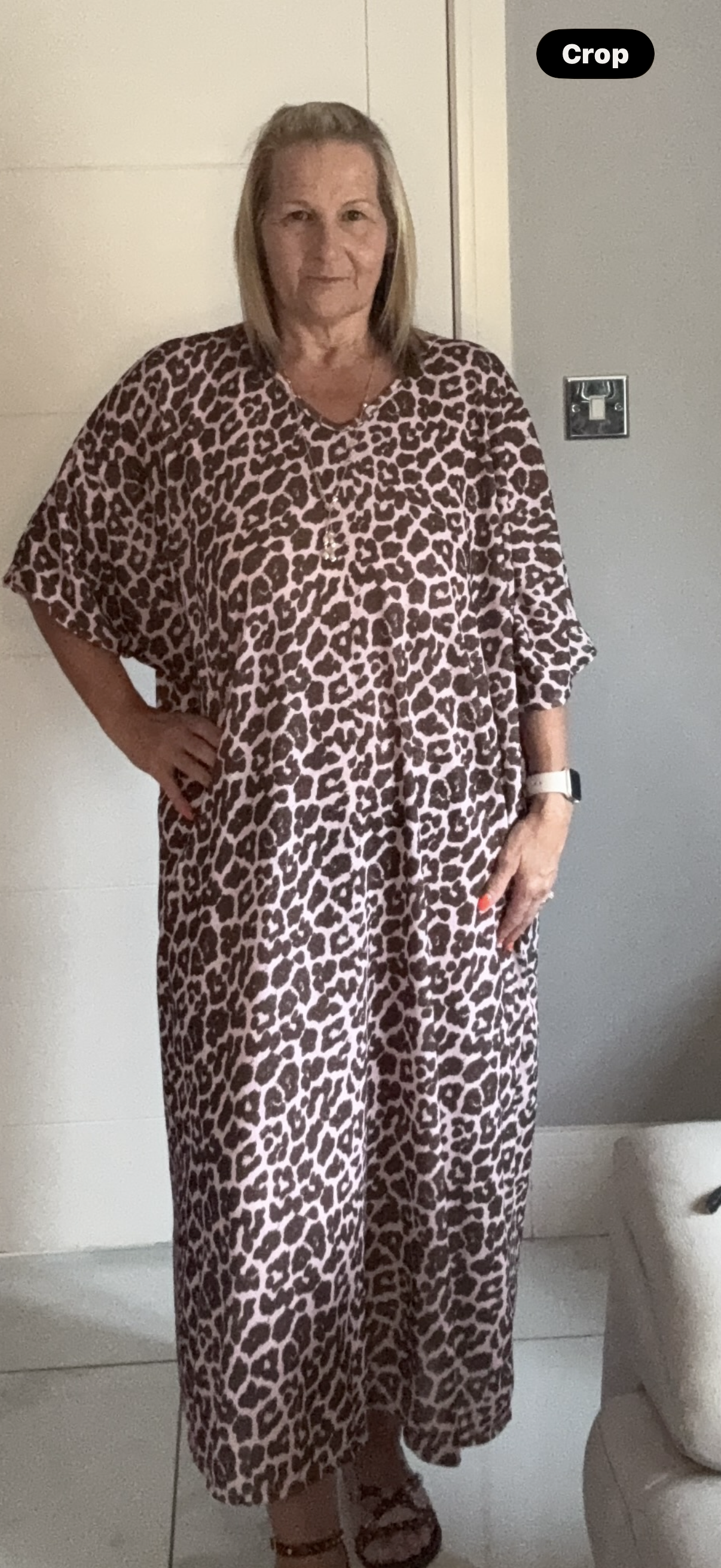 Woman wearing a leopard print dress indoors.