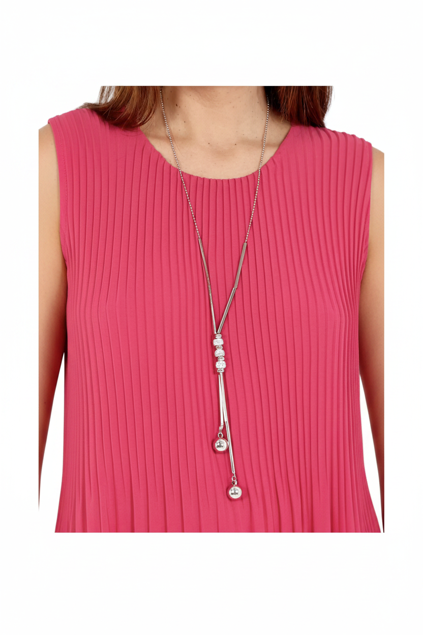 A silver-toned long necklace with a triple-bead charm and dangling tassel pendants, worn by a model in a pink pleated sleeveless top.