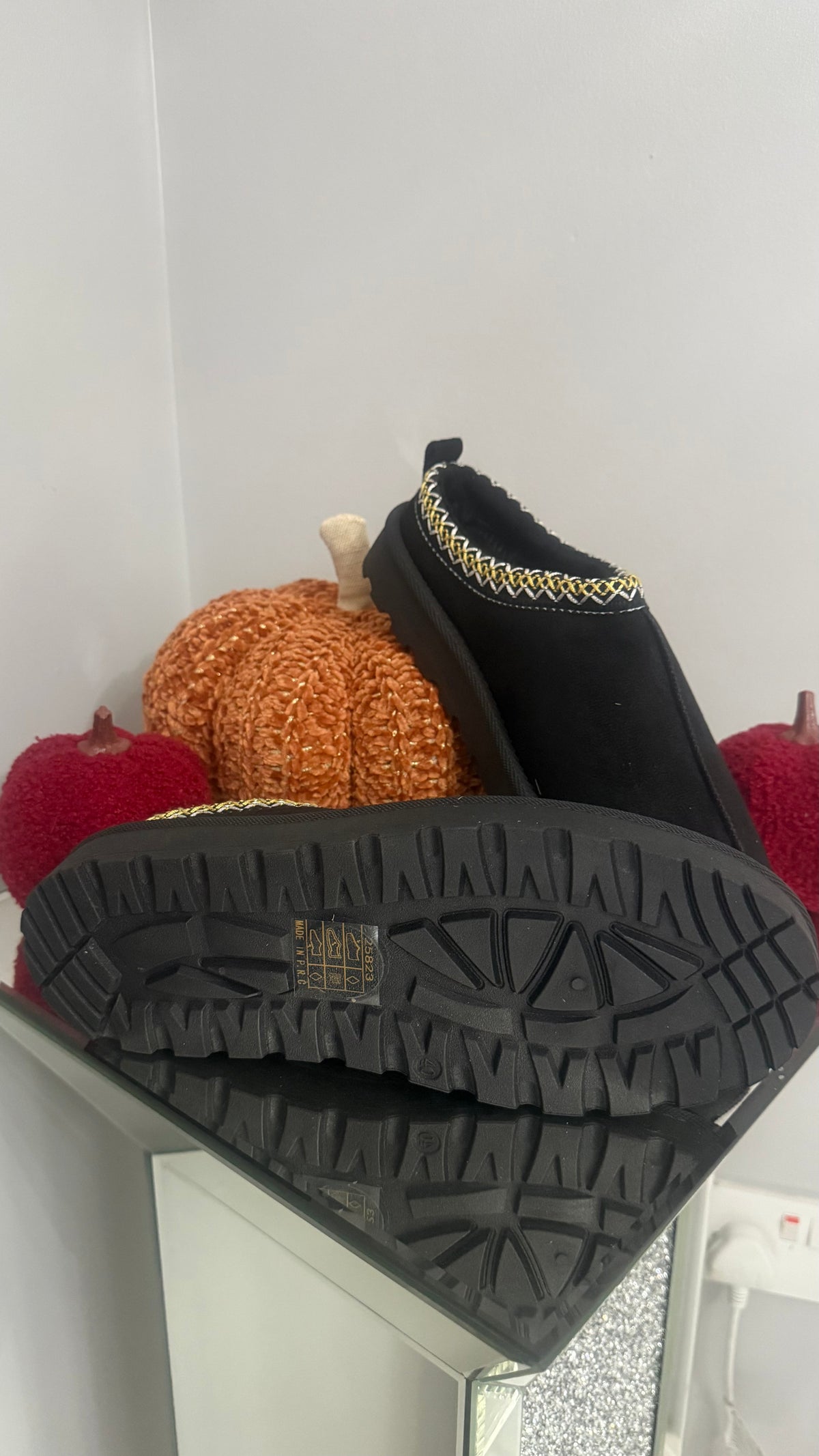 Black boots with a textured sole on a white background