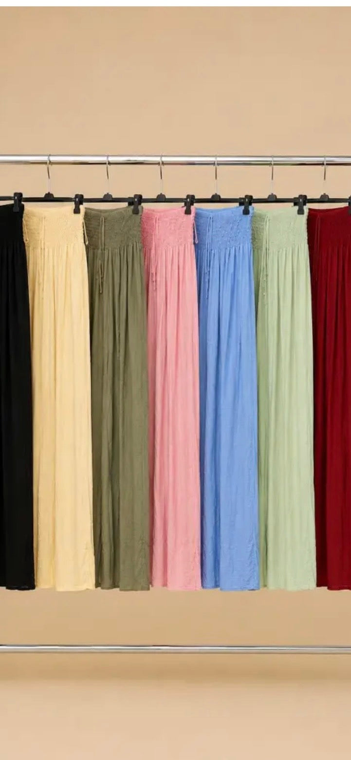 Set of colorful curtains hanging on a rod against a beige wall.