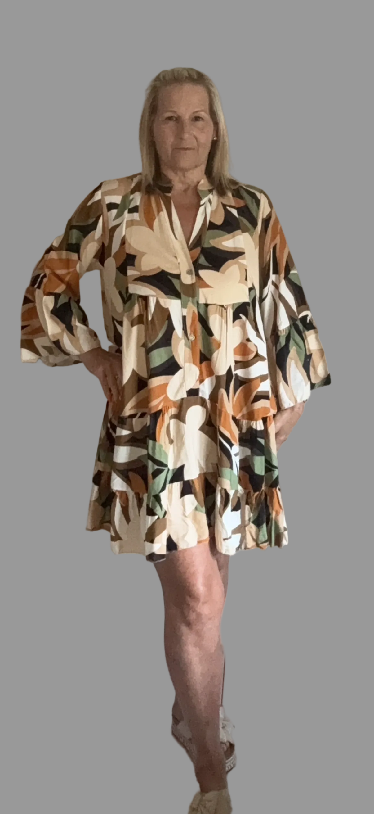 Woman wearing a patterned dress on a gray background