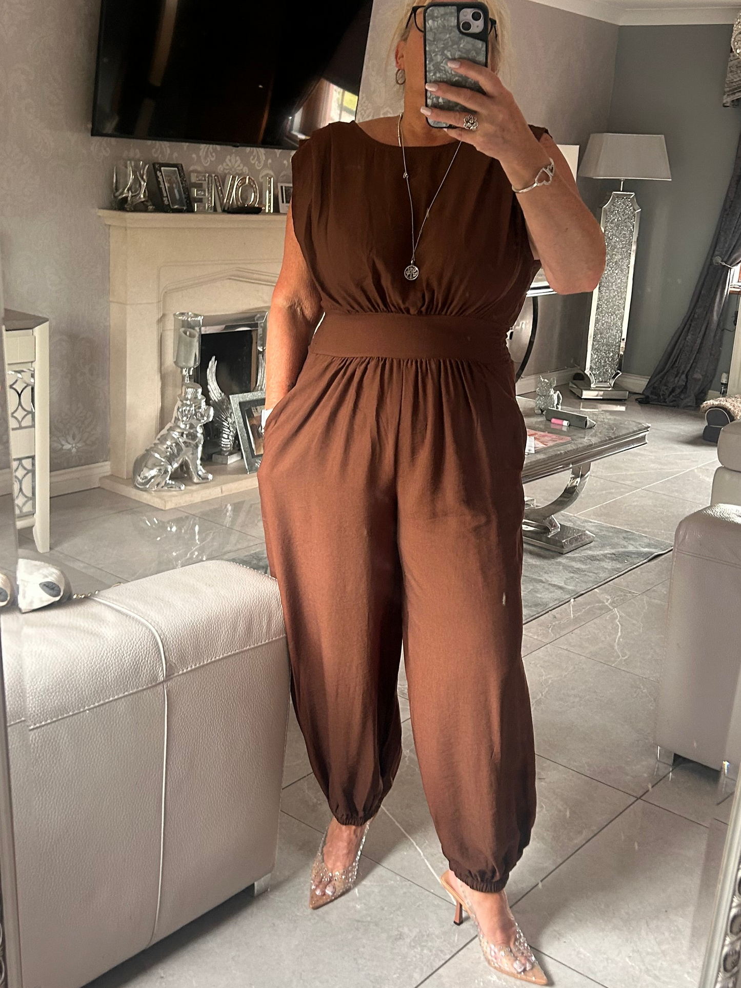 Person wearing a brown jumpsuit in a living room setting