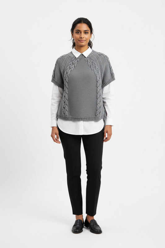 A gray hand-knit short-sleeve top with textured lace panels and side ties, hanging on a black hanger against a white paneled background.