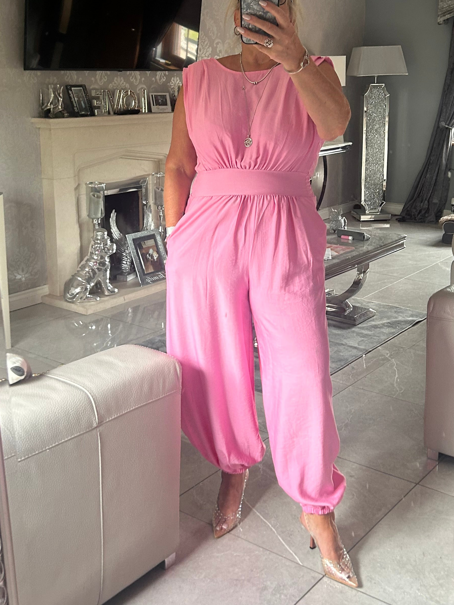 Person wearing a pink jumpsuit in a living room setting.