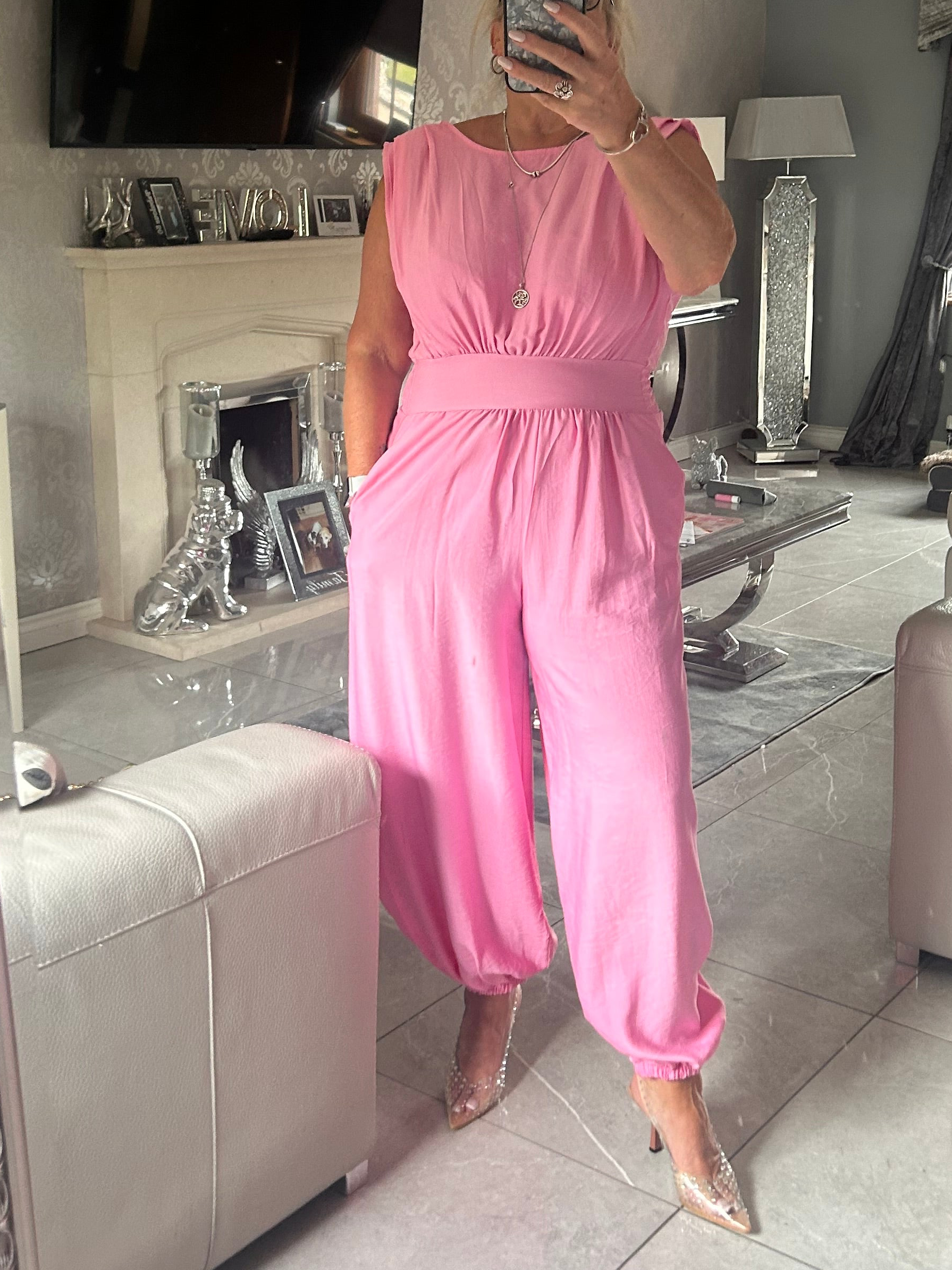 Person wearing a pink jumpsuit in a living room setting.