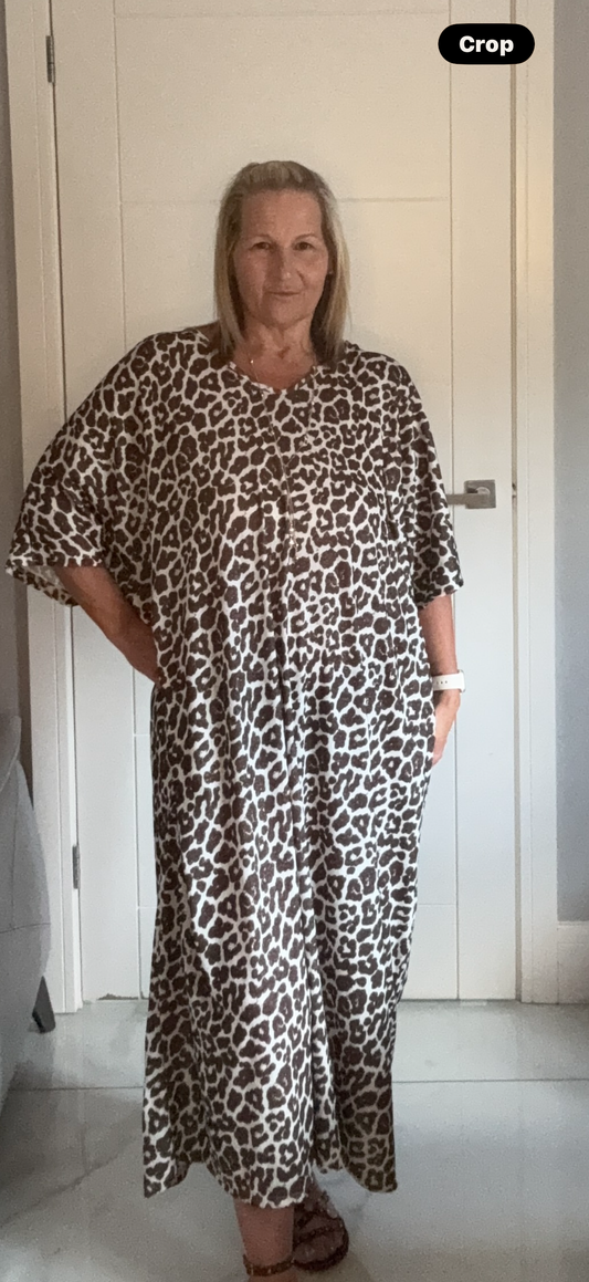 Woman wearing a leopard print dress with gold flecks and silk bow, one size fits 22-24"
