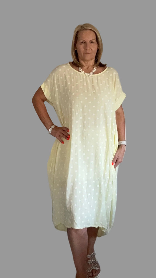 Woman wearing a light yellow dress on a gray background