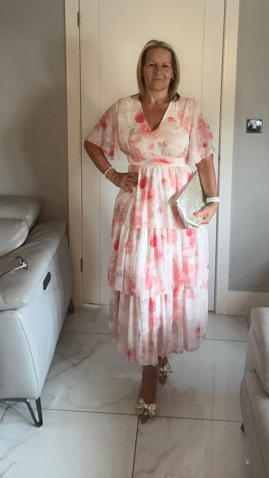 Woman in a floral dress standing in a living room.