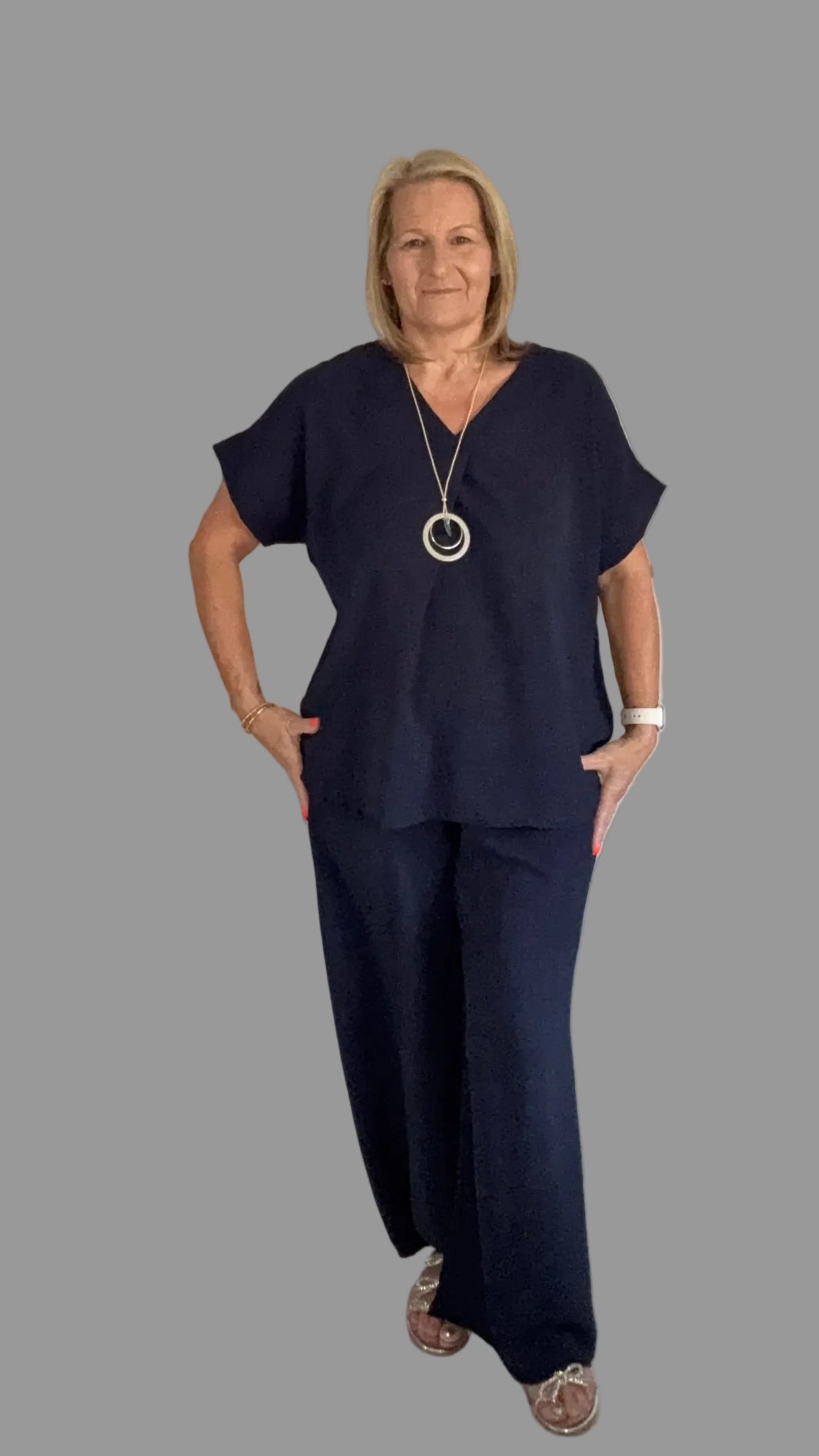 Woman in navy outfit grey background