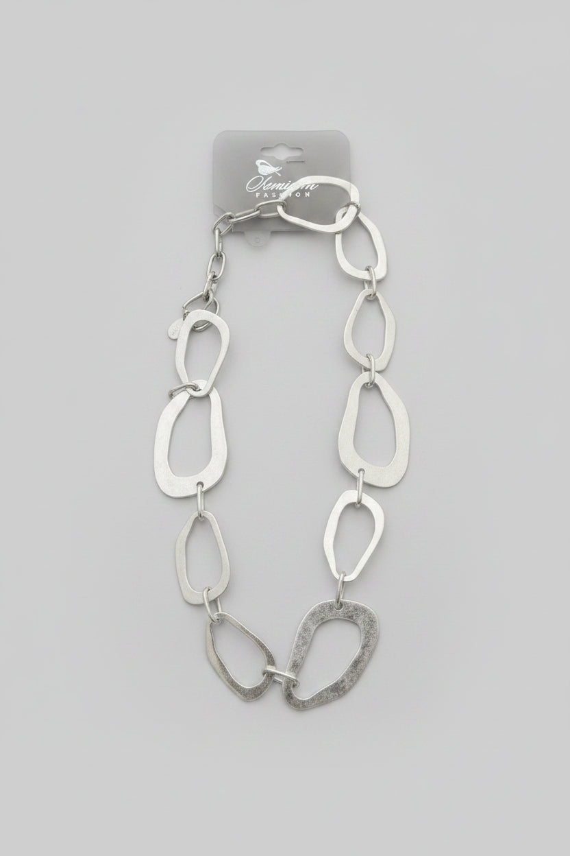 A chunky silver-toned link necklace with irregular, organic-shaped oval links, displaYED ON A WITE BACKGROUND