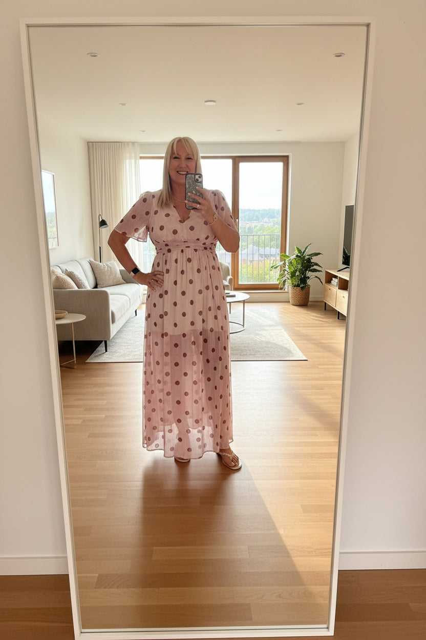Person in a pink polka dot dress taking a selfie