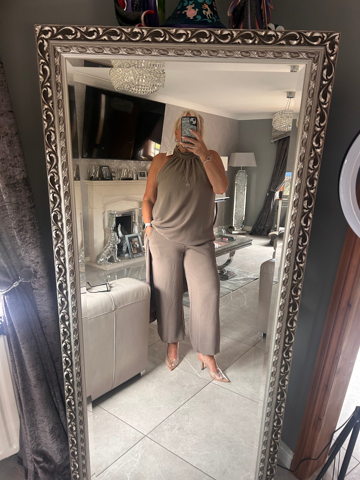 Person taking a mirror selfie in a room with decorative elements.