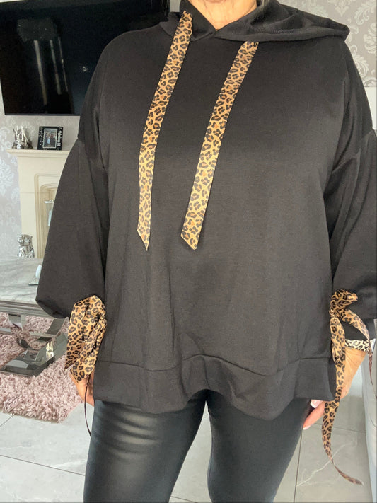 Black pants with leopard print accents worn by a person indoors.