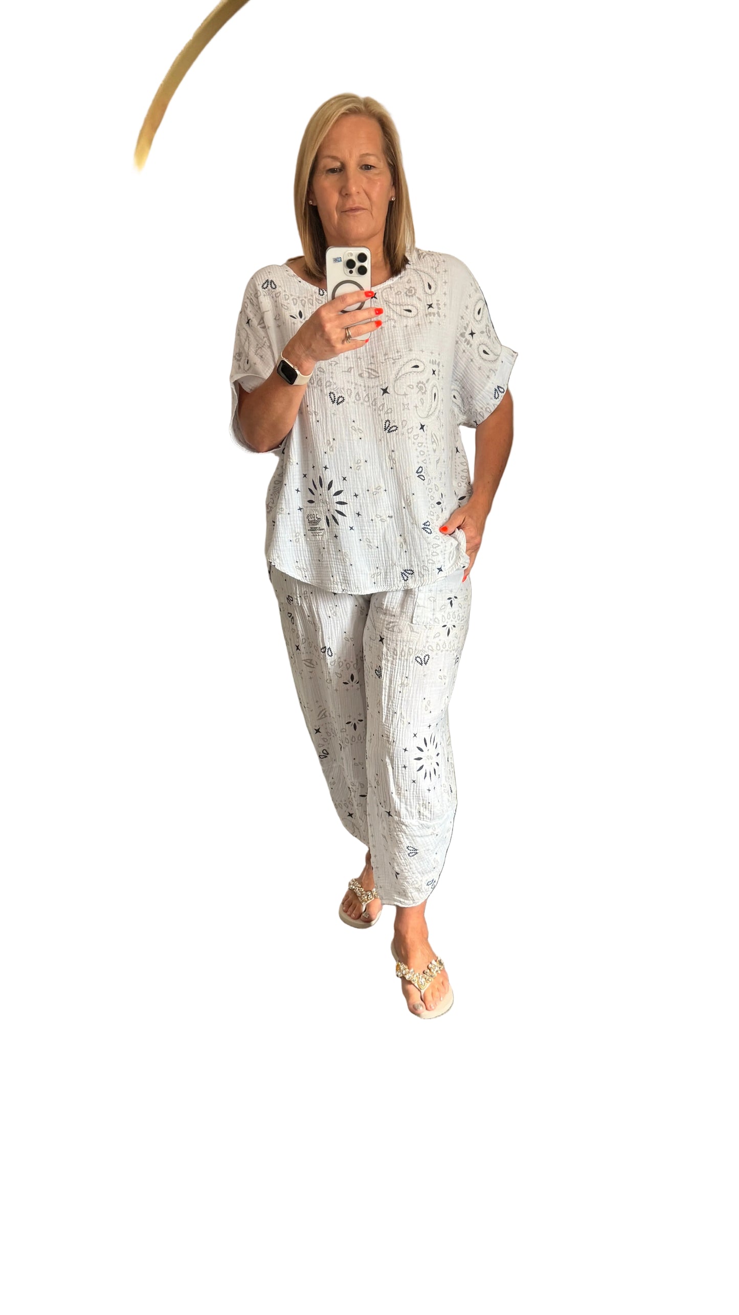 Woman taking a mirror selfie wearing a white Millie paisley suit  outfit on a white background


