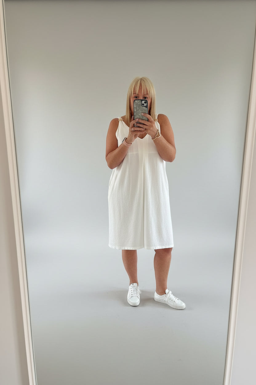 person showing white playsuit  taking a selfie