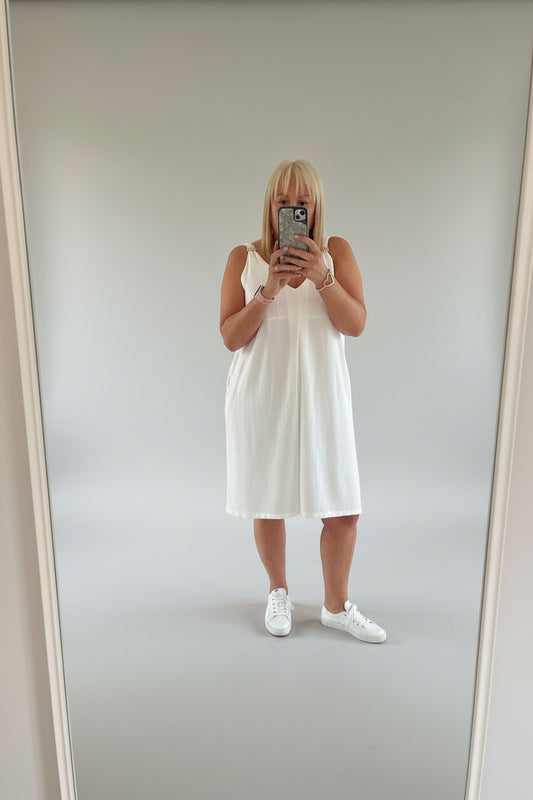 person showing white playsuit  taking a selfie