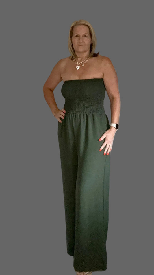 Woman wearing a strapless green jumpsuit on a Gray background