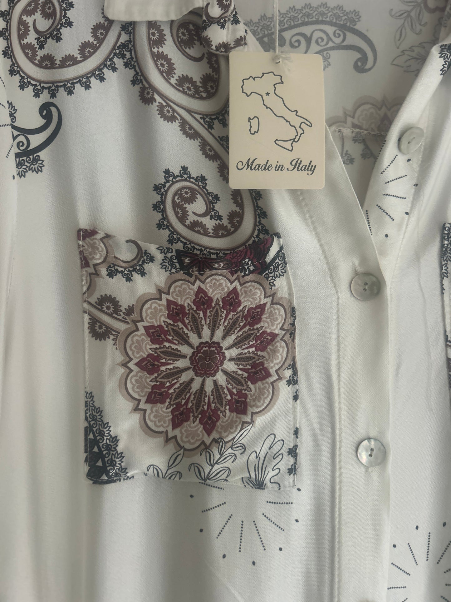 White garment with floral patterns and 'Made in Italy' tag