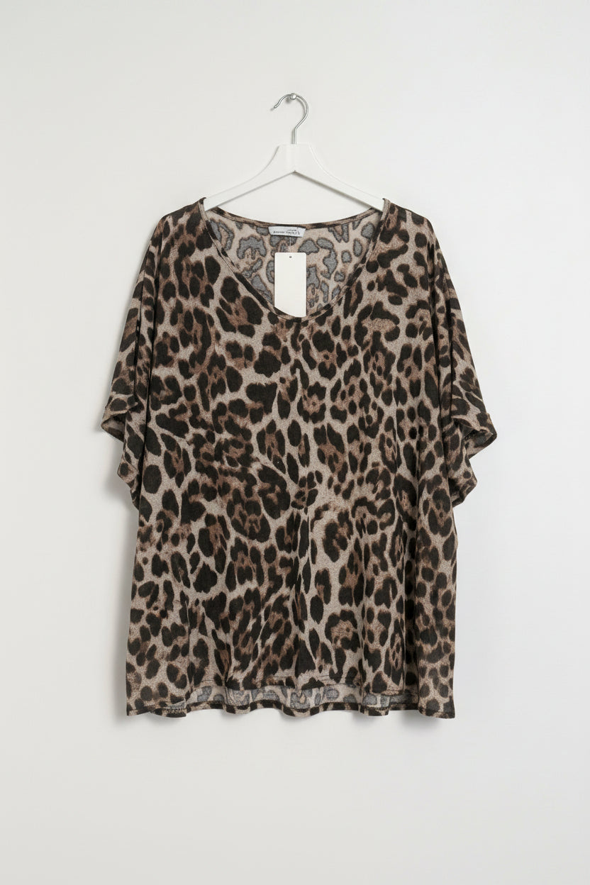 Leopard print top on a hanger against a white wall