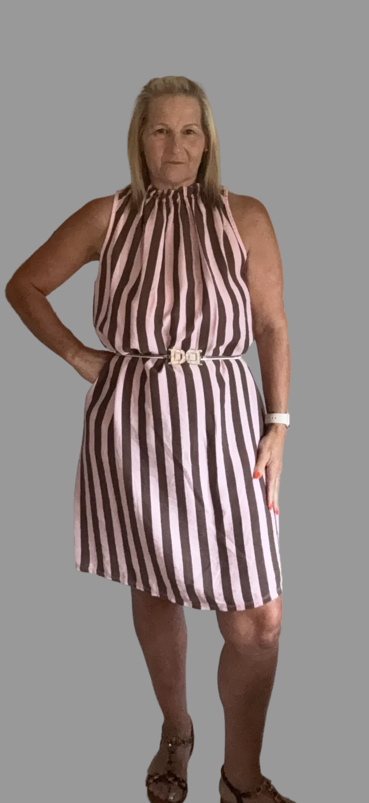 Woman wearing a brown and white striped dress on a gray background