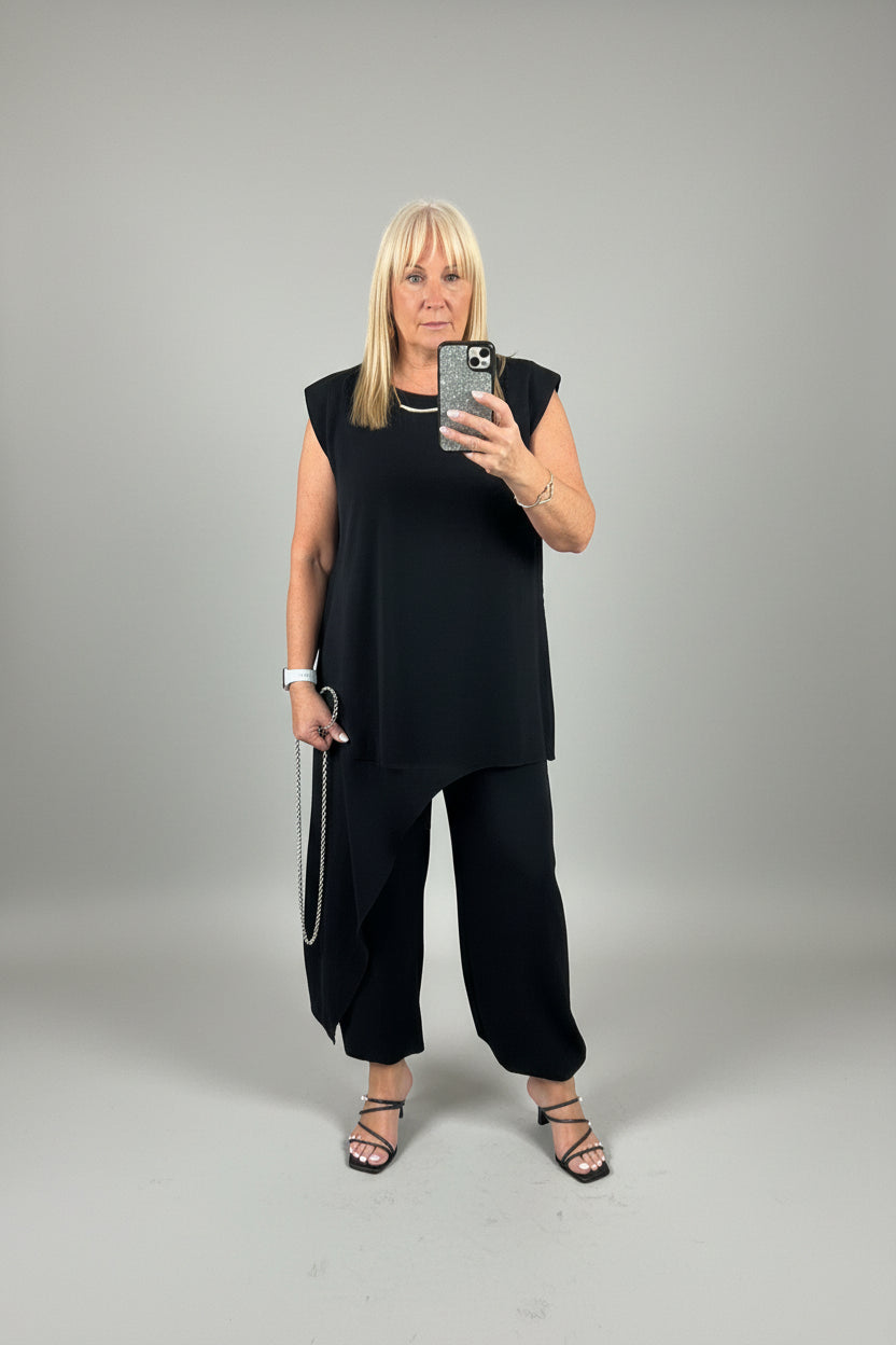 Model wearing the black Tanya asymmetrical suit taking a selfie
