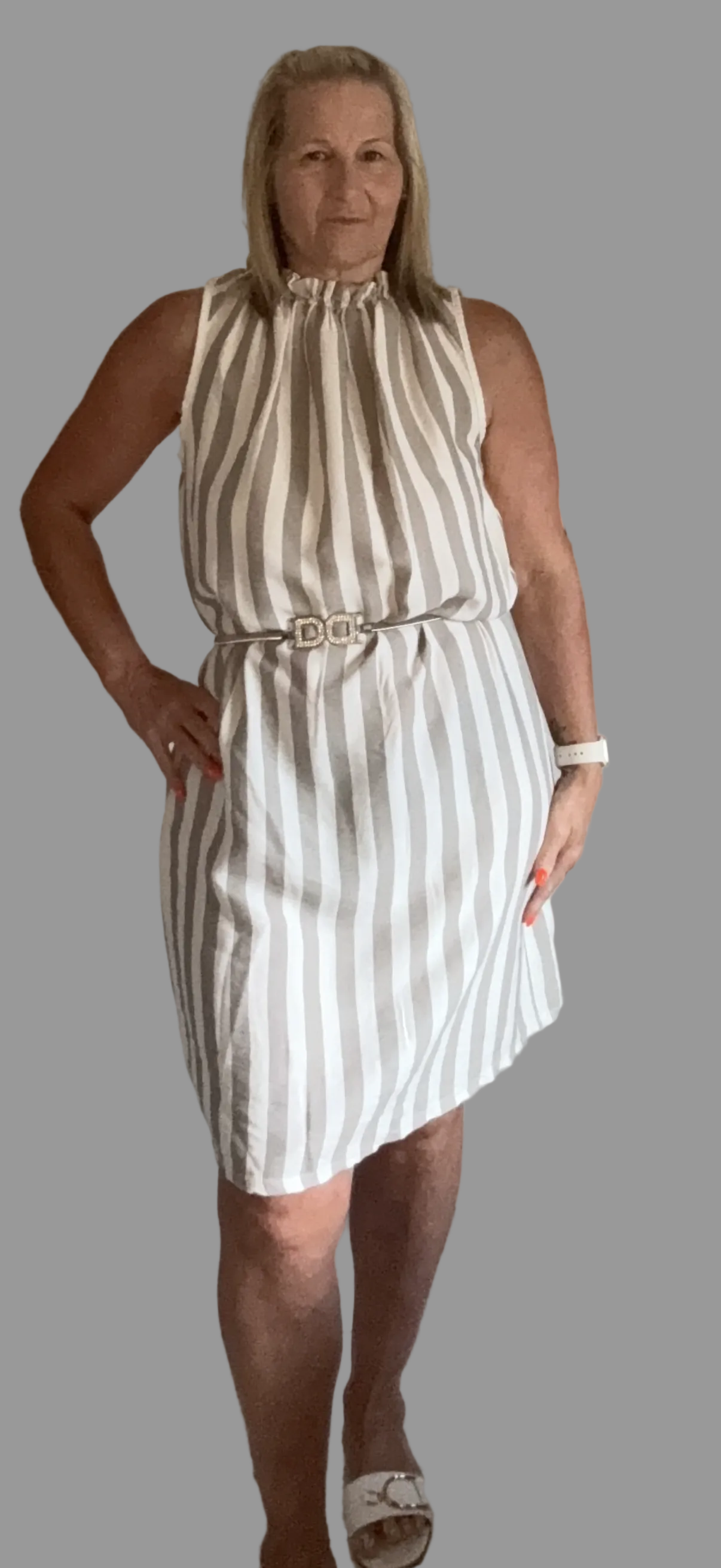Woman wearing a beige and white striped dress against a gray background