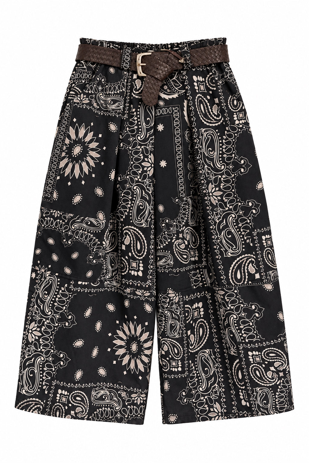 A pair of black wide-leg cropped pants with a brown and beige paisley bandana print, featuring a matching brown belt with a gold buckle, hanging on a black hanger against a white paneled door.